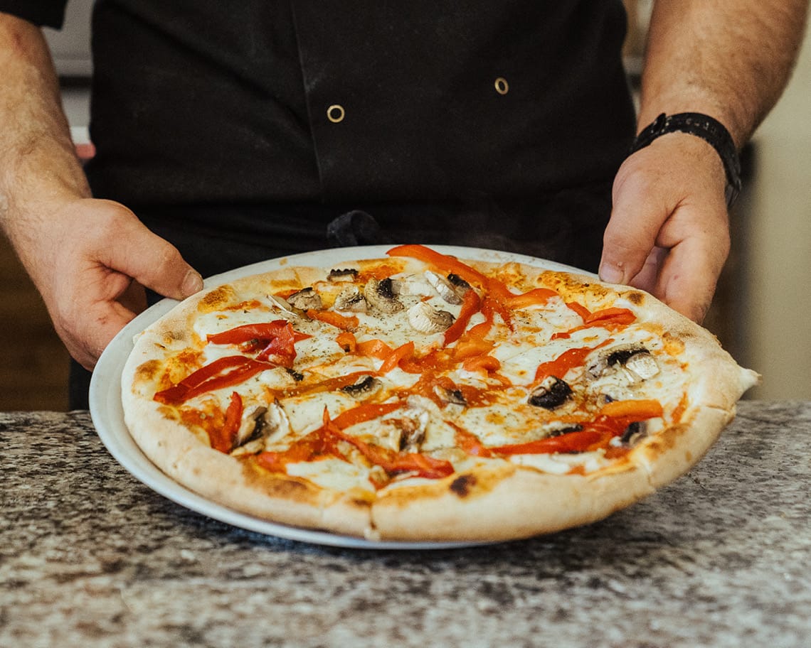 Frische Pizza wird präsentiert