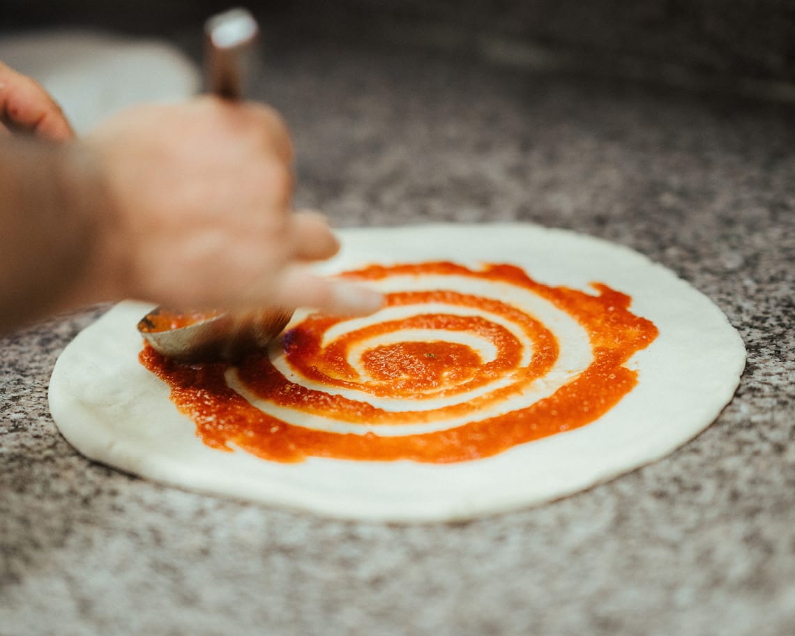 Eine Pizza wird belegt